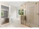 Bathroom showcases a glass shower, separate tub, and an outdoor view at 1203 Stone Harbour Rd, Winter Springs, FL 32708
