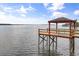 Waterfront dock with covered area, perfect for relaxing and enjoying stunning views of the tranquil lake at 1203 Stone Harbour Rd, Winter Springs, FL 32708