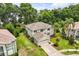 Aerial view of a two-story home with a two-car garage, neutral exterior, and lush tropical landscaping at 1203 Stone Harbour Rd, Winter Springs, FL 32708