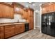 Kitchen featuring black appliances, wood cabinets, and light gray wood flooring at 1203 Stone Harbour Rd, Winter Springs, FL 32708