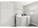 Clean laundry room with white washer and dryer, shelving, and a window at 1203 Stone Harbour Rd, Winter Springs, FL 32708