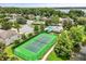 Aerial view of a tennis court close to the water with beautiful landscaping all around at 1203 Stone Harbour Rd, Winter Springs, FL 32708