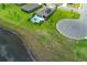 Panoramic aerial view of a home with pool, manicured backyard, solar panel, near a serene lake in a well-planned neighborhood at 1313 Middle Lake Dr, Ormond Beach, FL 32174