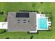 Aerial view of modern home with a refreshing swimming pool, gray roof and a solar panel in a well-manicured backyard at 1313 Middle Lake Dr, Ormond Beach, FL 32174
