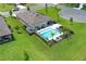 Aerial view of a home featuring an inviting swimming pool, patio area, solar panel, and beautifully landscaped yard with palm trees at 1313 Middle Lake Dr, Ormond Beach, FL 32174