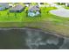Aerial view of a home featuring a sparkling pool, manicured lawn, and a serene lake view in a desirable neighborhood at 1313 Middle Lake Dr, Ormond Beach, FL 32174