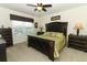 Bedroom with a ceiling fan, window, and dark wood furniture, plus a comfortable bed at 1313 Middle Lake Dr, Ormond Beach, FL 32174