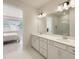 Bright bathroom with dual sinks and quartz countertops, with a view into the bedroom at 13562 Pearl Beach St, Winter Garden, FL 34787