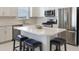 Modern kitchen with stainless steel appliances, white cabinets, quartz counters, and an eat-in kitchen island at 13562 Pearl Beach St, Winter Garden, FL 34787