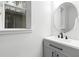 Modern half-bathroom featuring a sleek vanity with black hardware, a round mirror, and a window with natural light at 14126 Walcott Ave, Orlando, FL 32827
