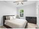 Clean and well-lit bedroom featuring a ceiling fan, a large bed, a window, and a dresser with storage at 14126 Walcott Ave, Orlando, FL 32827