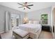 Bright bedroom features a ceiling fan, neutral walls, a large bed, and French doors to a balcony at 14126 Walcott Ave, Orlando, FL 32827
