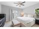 Inviting bedroom featuring a ceiling fan, neutral walls, a large bed, and French doors to a balcony at 14126 Walcott Ave, Orlando, FL 32827
