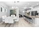 Open-concept dining area with a modern chandelier, white table and chairs, with kitchen in the background at 14126 Walcott Ave, Orlando, FL 32827