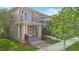 Charming townhome showcases a decorative porch with columns, manicured landscaping, and neutral exterior at 14126 Walcott Ave, Orlando, FL 32827
