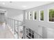 Bright hallway featuring modern railing, light hardwood floors, and multiple windows providing lots of natural light at 14126 Walcott Ave, Orlando, FL 32827