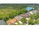 Beautiful aerial view of a home with mature trees, lush landscaping and a serene lake in the background at 14312 Paradise Tree Dr, Orlando, FL 32828