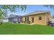 Well kept lawn with a screened in pool and spa and white picket fence to the side of the house at 14312 Paradise Tree Dr, Orlando, FL 32828