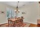 Dining room with hardwood floors, area rug, chandelier, shuttered window and a dark wood table with six chairs at 14312 Paradise Tree Dr, Orlando, FL 32828