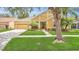 Single-Gathering home featuring a well-manicured lawn, lush landscaping, and two-car garage on a sunny day at 14312 Paradise Tree Dr, Orlando, FL 32828