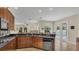 Open kitchen featuring dark countertops, wood cabinets and stainless steel appliances, flowing into the living room and pool area at 14312 Paradise Tree Dr, Orlando, FL 32828