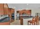Spacious kitchen featuring wood cabinets, stainless steel appliances, tile backsplash, and a breakfast bar with seating at 14312 Paradise Tree Dr, Orlando, FL 32828