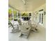 Covered patio with rocking chairs and dining set, perfect for relaxing and entertaining outdoors at 14344 Desert Haven St, Windermere, FL 34786