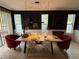 Dining room with modern decor, including a wood table, pendant lights, and red accent chairs at 14344 Desert Haven St, Windermere, FL 34786