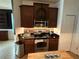 Kitchen featuring stainless steel appliances, granite countertops and dark wood cabinets at 14344 Desert Haven St, Windermere, FL 34786