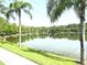 Picturesque lake view framed by swaying palm trees and lush greenery, offering a serene and tranquil setting at 14344 Desert Haven St, Windermere, FL 34786