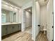 Bathroom with gray cabinetry, wood-look tile, and a view into the walk-in closet and toilet room at 148 Hampton Loop, Davenport, FL 33837