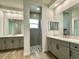 Bright bathroom with gray cabinetry and a view of the shower featuring hexagon tile and a window at 148 Hampton Loop, Davenport, FL 33837