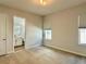 Cozy bedroom features neutral carpet, natural light, and an en-suite bathroom at 148 Hampton Loop, Davenport, FL 33837