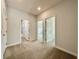 Bright bedroom features neutral walls, plush carpet, and doorways leading to other rooms at 148 Hampton Loop, Davenport, FL 33837