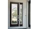 Elegant front door with glass panels and a modern electronic lock system at 148 Hampton Loop, Davenport, FL 33837