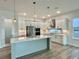 Island kitchen featuring stainless steel appliances, wood-style floors, and quartz countertops at 148 Hampton Loop, Davenport, FL 33837