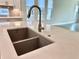 Close-up of a kitchen sink with modern faucet and quartz countertop at 148 Hampton Loop, Davenport, FL 33837