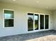 Covered lanai with stone tile, large windows, and a view of the backyard at 148 Hampton Loop, Davenport, FL 33837