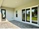 Covered lanai featuring stone tile, exterior door, and large sliding glass doors overlooking backyard at 148 Hampton Loop, Davenport, FL 33837