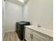 Bright laundry room features a washing machine and dryer and a utility sink with white cabinetry at 148 Hampton Loop, Davenport, FL 33837