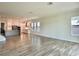 Spacious living area with wood flooring and modern kitchen in the background at 148 Hampton Loop, Davenport, FL 33837