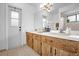 Bathroom with double sinks, wooden cabinets, and a door to the outside at 1508 Southwind Ct, Casselberry, FL 32707