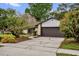 Inviting single-story home with a manicured lawn, mature trees, and a spacious two-car garage at 1508 Southwind Ct, Casselberry, FL 32707
