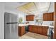 Bright kitchen featuring white countertops, warm wood cabinets, modern appliances, and stainless-steel refrigerator at 1508 Southwind Ct, Casselberry, FL 32707