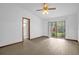 Spacious main bedroom featuring wood floors, a ceiling fan, sliding door access to the backyard and an ensuite bathroom at 1508 Southwind Ct, Casselberry, FL 32707