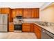 Well-equipped kitchen featuring granite countertops, stainless steel appliances, and classic wood cabinets at 168 Hill St, Casselberry, FL 32707