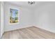 Minimalist bedroom featuring hardwood floors, a ceiling fan, and a bright window at 17657 Windy Pine St, Montverde, FL 34756