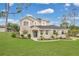 Beautifully landscaped two-story home with a blue front door and lush green lawn at 17657 Windy Pine St, Montverde, FL 34756