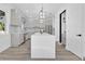 Modern kitchen featuring an oversized island, stylish light fixtures, and stainless steel appliances at 17657 Windy Pine St, Montverde, FL 34756