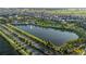 Scenic aerial view of a tranquil lake with a fountain, surrounded by lush landscaping and community homes at 1836 Sandy Park Trl, Kissimmee, FL 34747